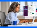 Woman sitting at desk using Slackbot AI agent for productivity in business with icon on screen.