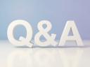 Three-dimensional white q and a letters standing on a reflective white surface against a soft purple and blue gradient background, clean studio light