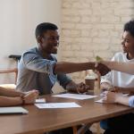 Cliente satisfeito aperta a mão de executivo em reunião de negócios no escritório.