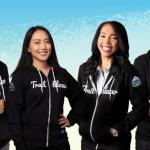 Dois homens e duas mulheres sorridentes vestindo agasalhos com a inscrição trailblazer