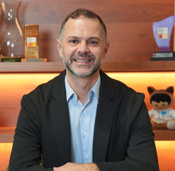 Leandro está em pé, sorrindo