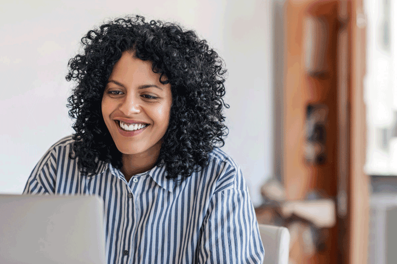 eine Frau sitzt an einem Laptop und erstellt E-Mai Nurturing Journeys