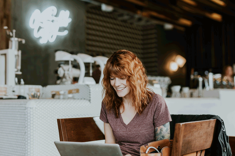 Eine Frau sitzt in einem Café am Laptop