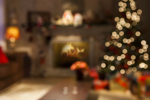 Das Bild zeigt ein verschwommenes Wohnzimmer mit Weihnachtsbaum und Kamin als Symbolbild für das Weihnachtsgeschäft 2022