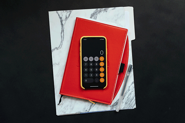 Marketingbudgets: Das iPhone liegt auf einem roten Notizbuch.