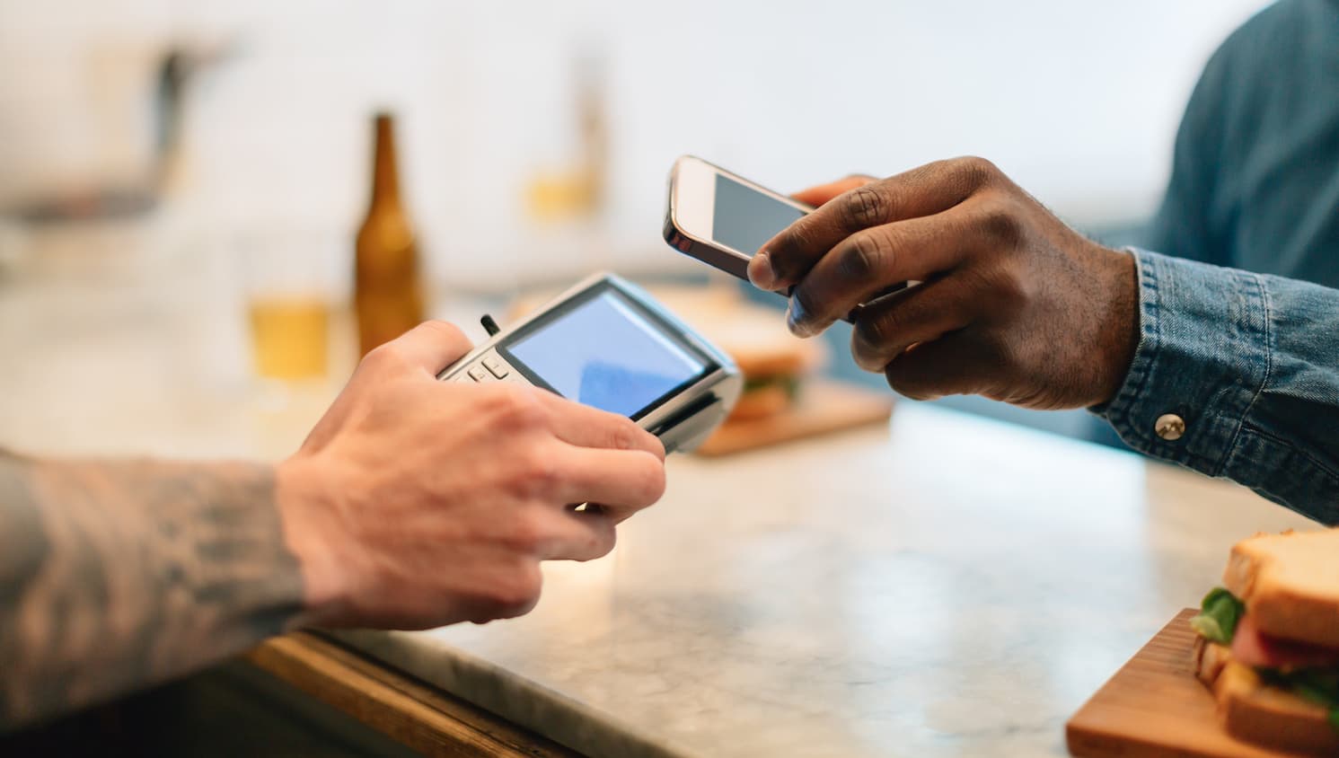 Pagare il pranzo con un portafoglio digitale è solo uno dei modi in cui la tecnologia mobile sta cambiando l'esperienza del cliente. [@BONNINSTUDIO/Stocksy United]