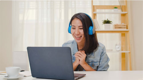 Young woman with headphones on laptop