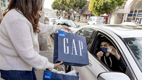 Mujer entregando una bolsa de GAP
