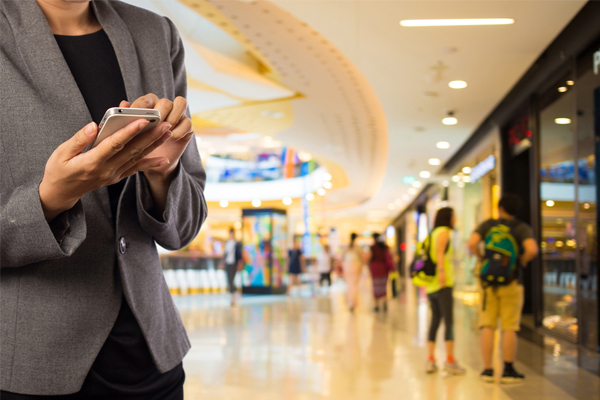 Image of Person Holding a Mobile Phone to Show 4 Ways Retailers Use Mobile For Better Customer Experiences