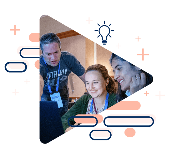 Group of Tableau Conference attendees pointing and smiling at a computer during a hands-on training.