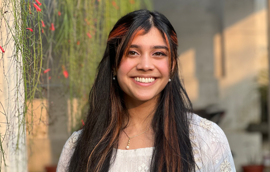 Tre Robinson from technology and product team sitting on a bench smiling at the camera