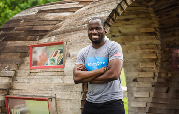Bunmi Akintomide from the business technology team wearing a salesforce shirt and smiling with his arms crossed 