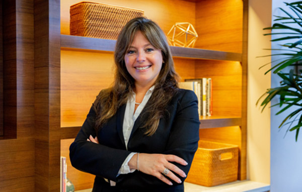 Elaine Schultz from the real estate and workplace services team smiling with arms crossed in the new york office