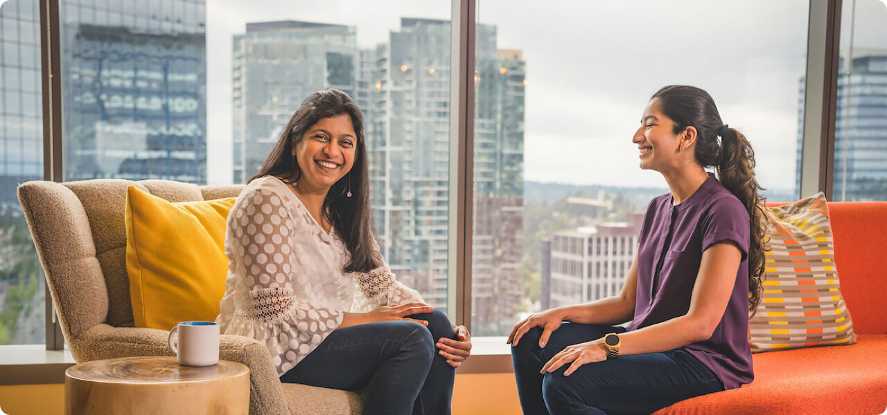 two employees sitting and laughing in the salesforce tower