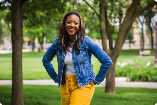 Kai Johnson smiling and posing for the camera in a park