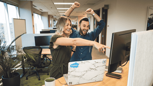 people cheering at monitor