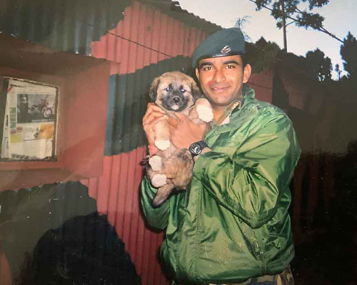 Manish is holding a puppy while he was serving