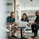 drei Personen sprechen über ihre B2B Ecommerce Strategie in einem Büro