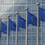 Vor einem Gebäude sind mehrere EU Flaggen zu sehen