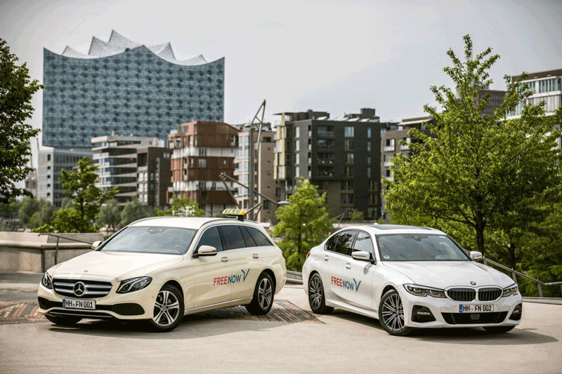 Zwei Autos von FREE NOW vor der Elbphilharmonie in Hamburg