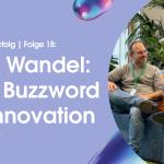 Podcast-Gast: Tolga Erdogan; 2 Männer, beide mit Brille, sitzen auf Couch, der Gastgeber mit Glatze spricht ins Mikrophon