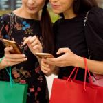 Dos compradores utilizan sus teléfonos móviles para comprar artículos: contenido shoppable