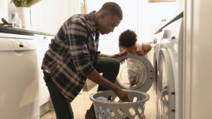 Un padre con su hija poniendo la lavadora