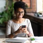 Una mujer utiliza su smartphone en un escritorio