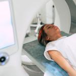 Young woman patient is ready to do magnetic resonance imaging in the modern hospital laboratory