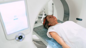 Young woman patient is ready to do magnetic resonance imaging in the modern hospital laboratory