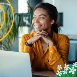 A seller sits in front of a laptop and smiles after learning how to get a job in sales.