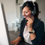 Woman on the phone in front of a computer: sales prospecting