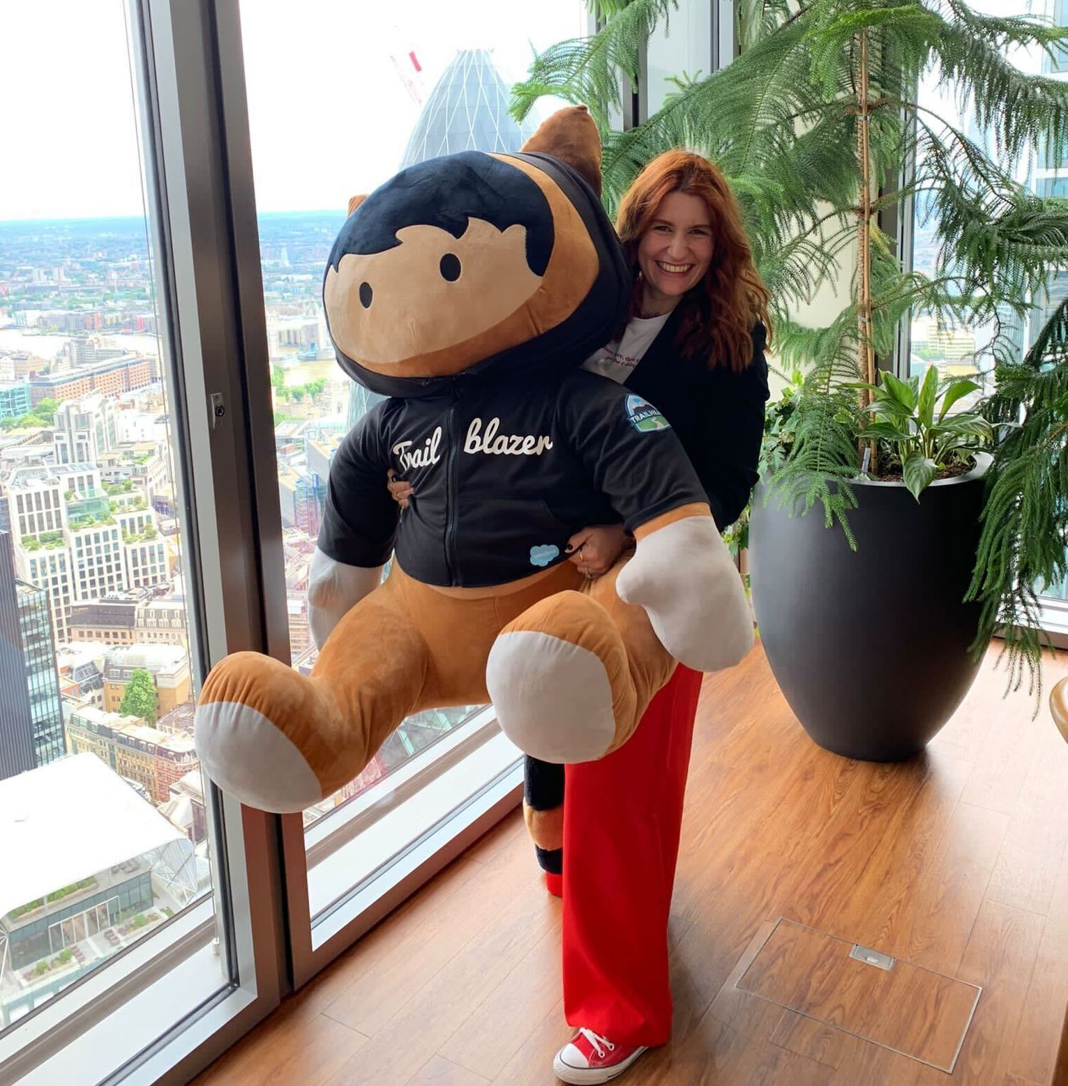 Sue Leandro hugging a giant Astro teddy in the Salesforce Tower London