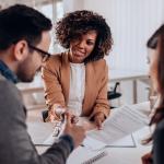 Trois employés discutent autour d'une table.