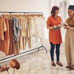 Photo d'une vendeuse et d'un client dans une boutique de vêtements, regardant une tablette / intégration zéro copie