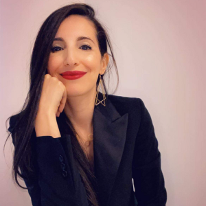 Portrait professionnel de Siham Atbane souriant, le menton posé sur sa main