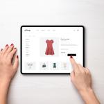 Online shopping with a tablet. Red women's dress on the e-commerce web page
