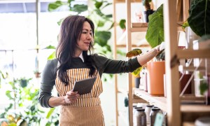 A woman who is a small business owner, stocking shelves for inventory.