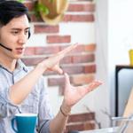 Man wearing his headphones takes a meeting via his laptop