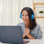 Young woman with headphones on laptop