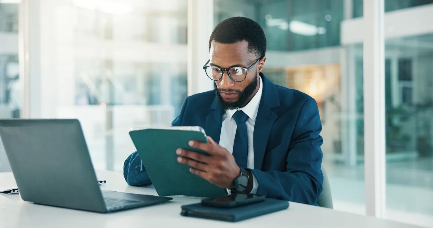 Business professional using tablet and laptop for financial management and business analytics