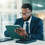 Business professional using tablet and laptop for financial management and business analytics