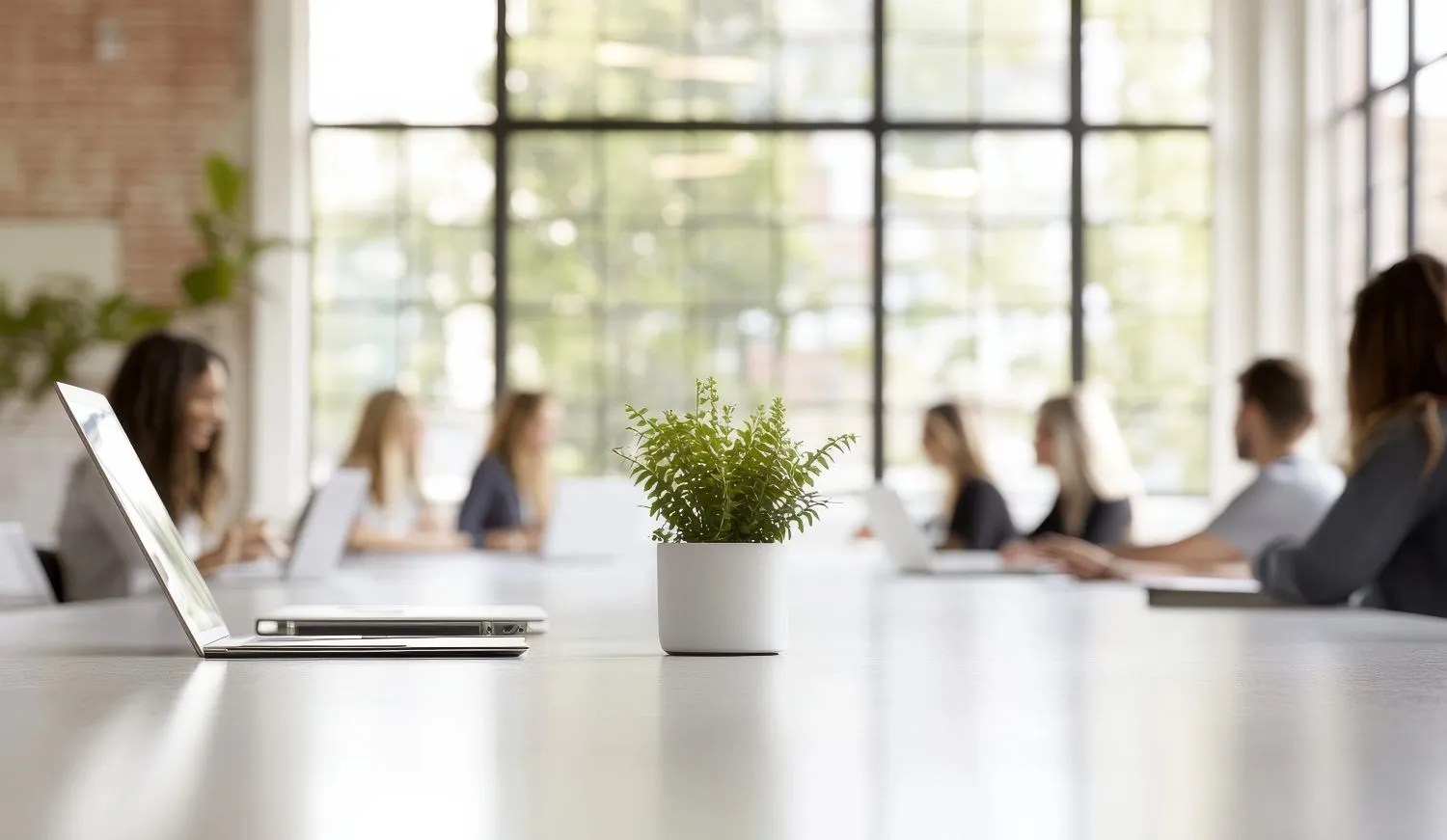 Office team working at desks around a plant-filled table on a businessfrontpage.