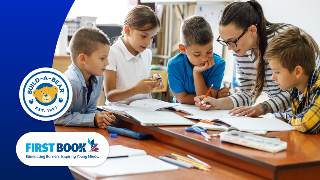 Teacher and elementary students gather around a table with their workbooks.