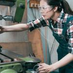 side view woman working on industrial manufacturing equipment / manufacturing partners