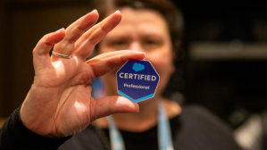 Photo of a man holding up a badge that says Certified Professional / Salesforce AI certification