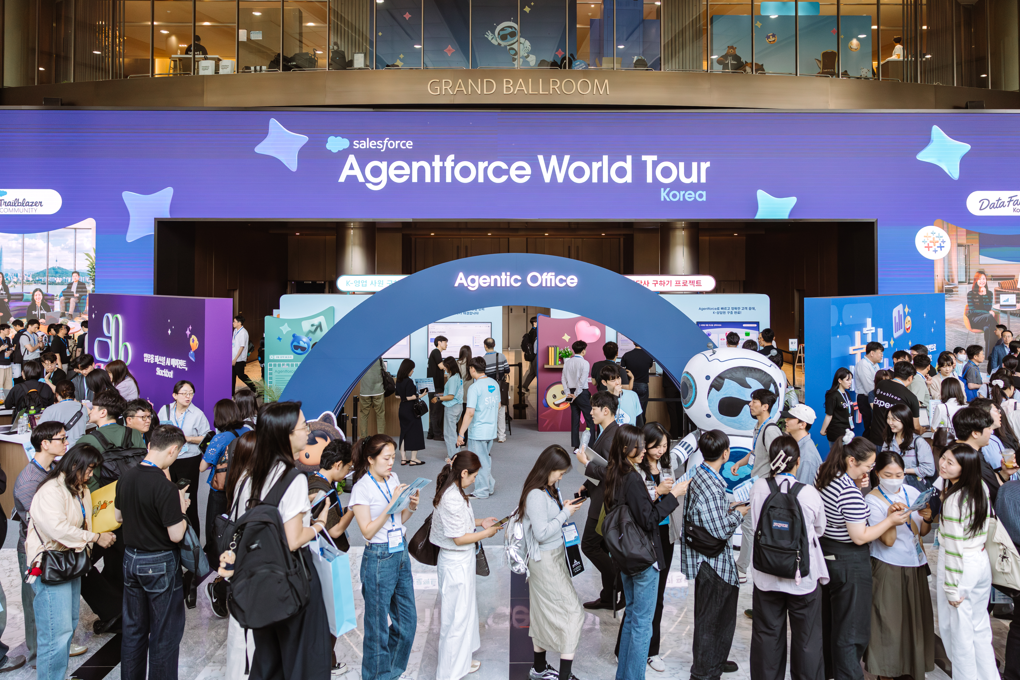 Agentforce World Tour Korea 2026 행사장 내 에이전틱 오피스(Agentic Office) 체험 부스 전경. 세일즈포스 AI 에이전트를 직접 경험하기 위해 수많은 참가자들이 줄을 서서 대기하고 있는 활기찬 현장 모습.