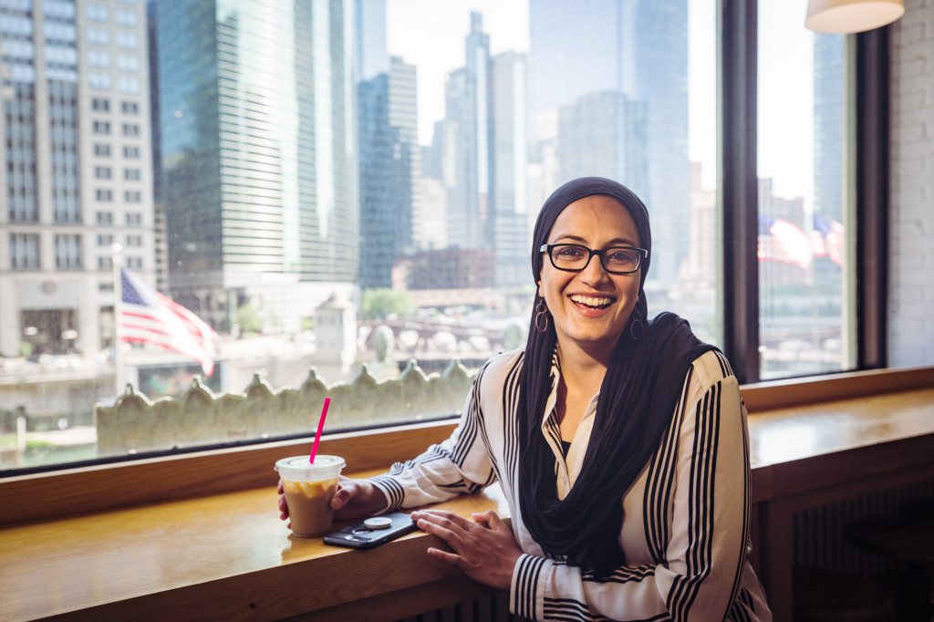 A Salesforce employee in Chicago enjoys a coffee while looking out at the river.