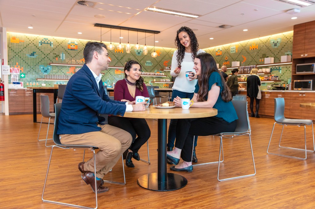 Employees at Salesforce Sydney chat in the kitchen.