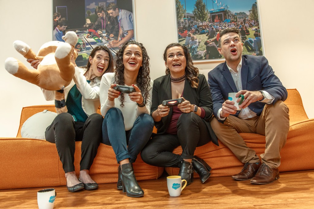 Employees at Salesforce Sydney enjoy friendly competition with a video game break.